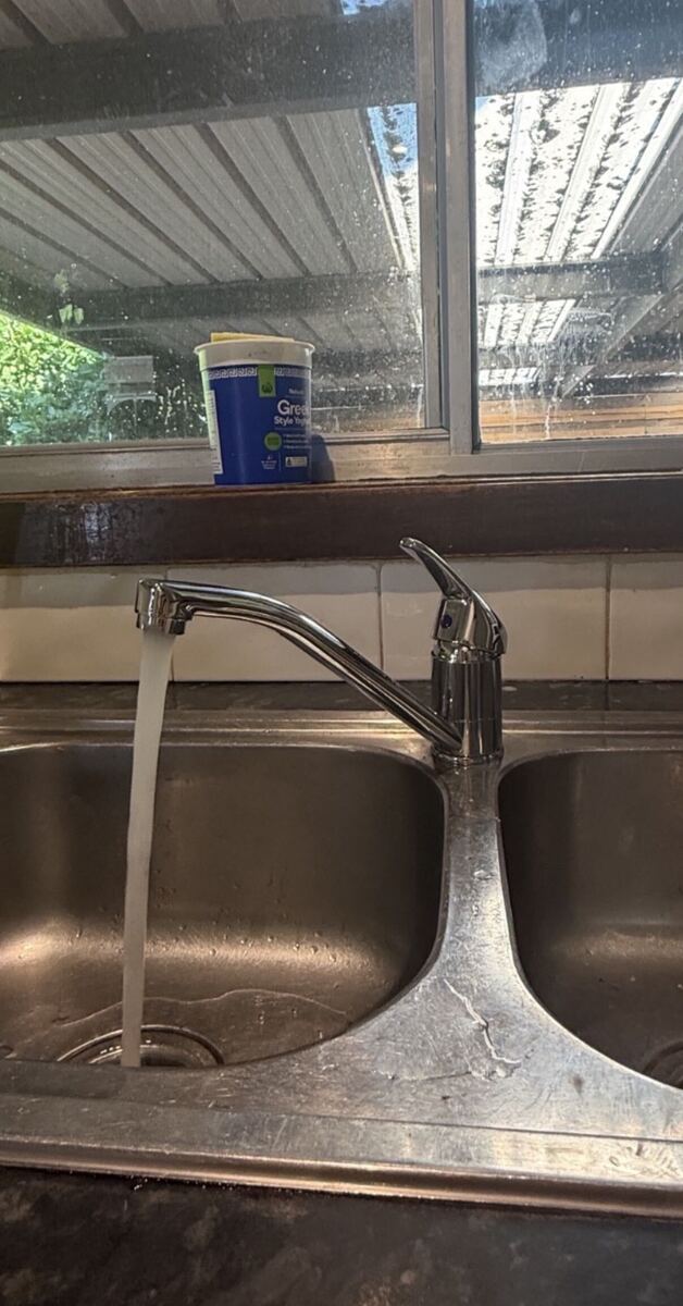 A newly installed kitchen mixer running clear water